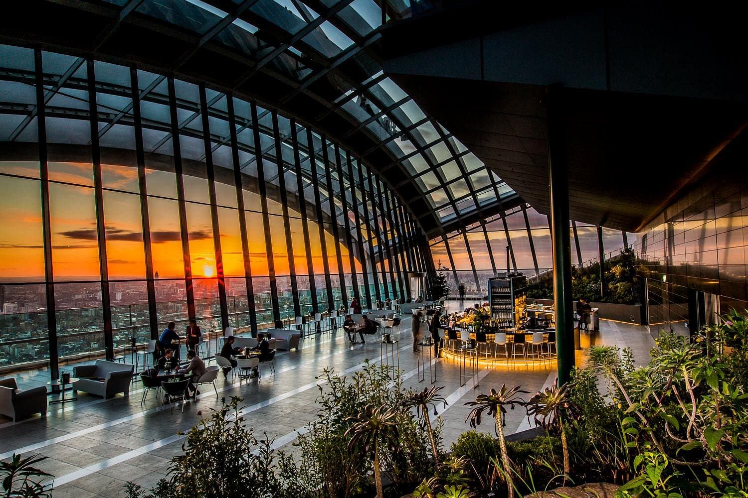 Sky Garden at sunset, the City through the vaulted glass wall.